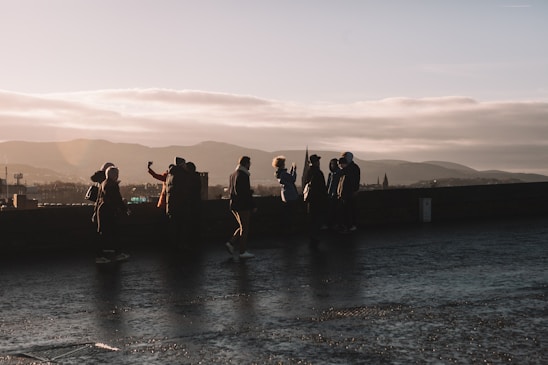 A vibrant photo of a diverse group of travelers laughing together on a scenic mountain trail at sunset.