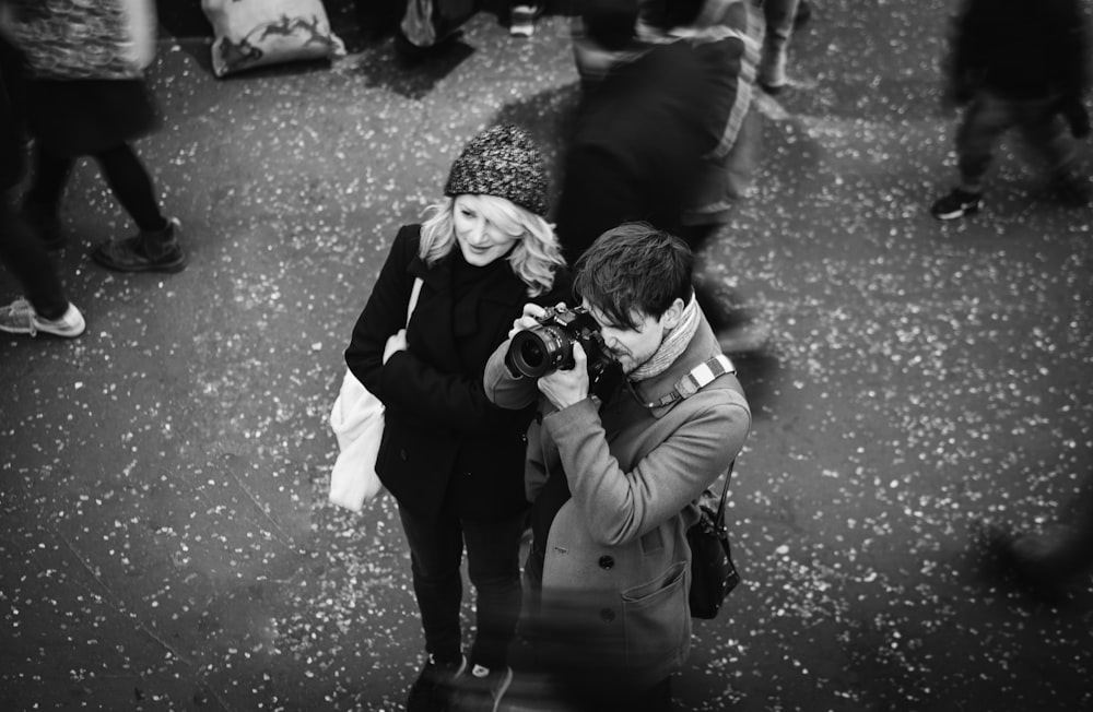 grayscale photography of man taking a photo