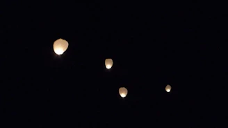 A soft watercolor illustration of a glowing lantern floating gently in the night sky.