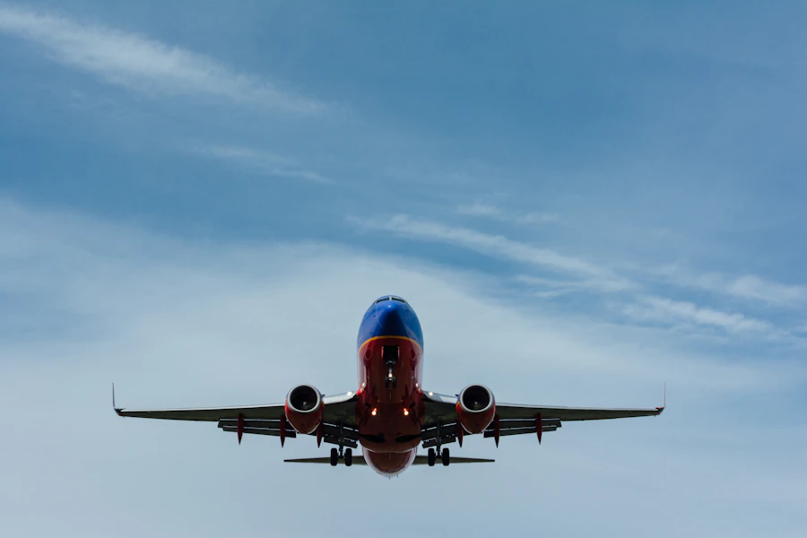 Airliner climbing away from the runway against a pale blue sky