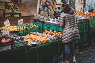 woman in front of fruit stands in market
