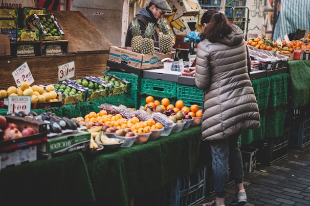 woman in front of fruit stands in market