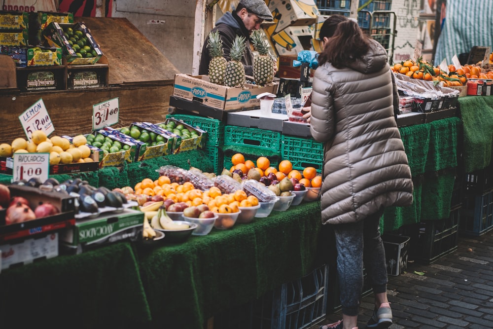 Donna davanti alle bancarelle di frutta nel mercato