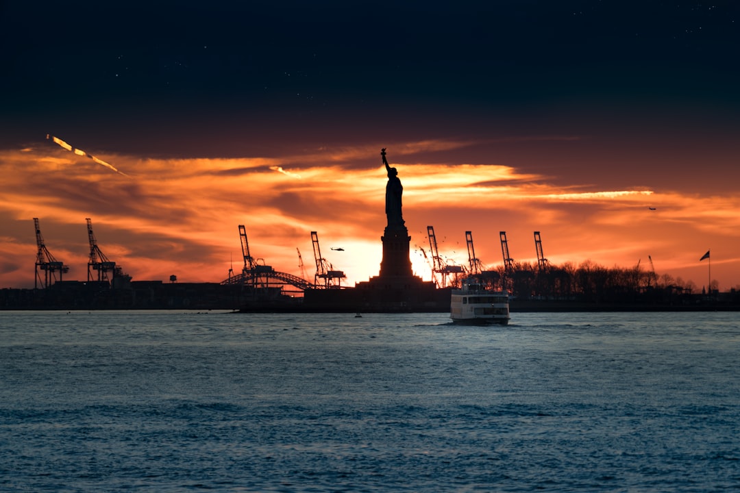 silhouette of Statue of Liberty near body of water