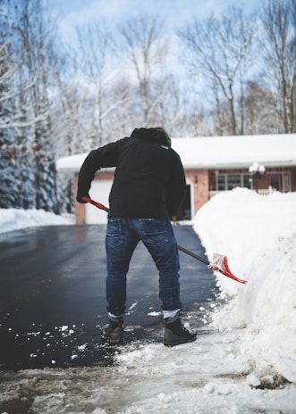 A team member clearing snow from a driveway.