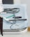 A close-up view of a medical tray with various dental tools, including a dental drill, orthodontic braces, and a small green dental brush on a blue sterile cloth.