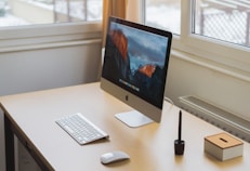 turned on silver iMac on table