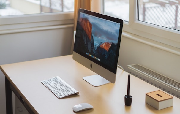 turned on silver iMac on table