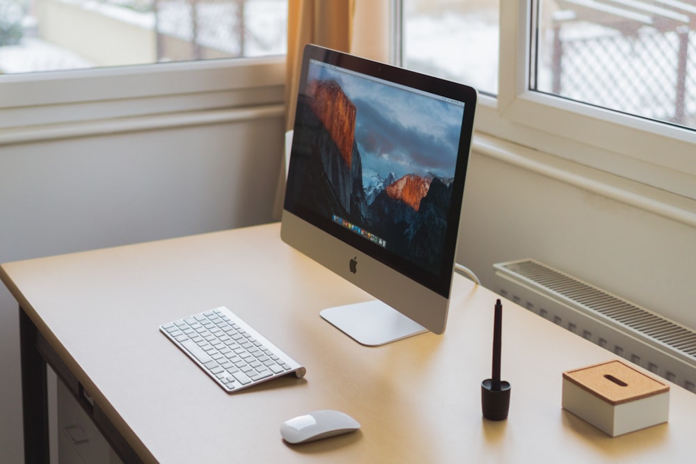 turned on silver iMac on table