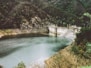 body of water in the middle of hills and concrete wall