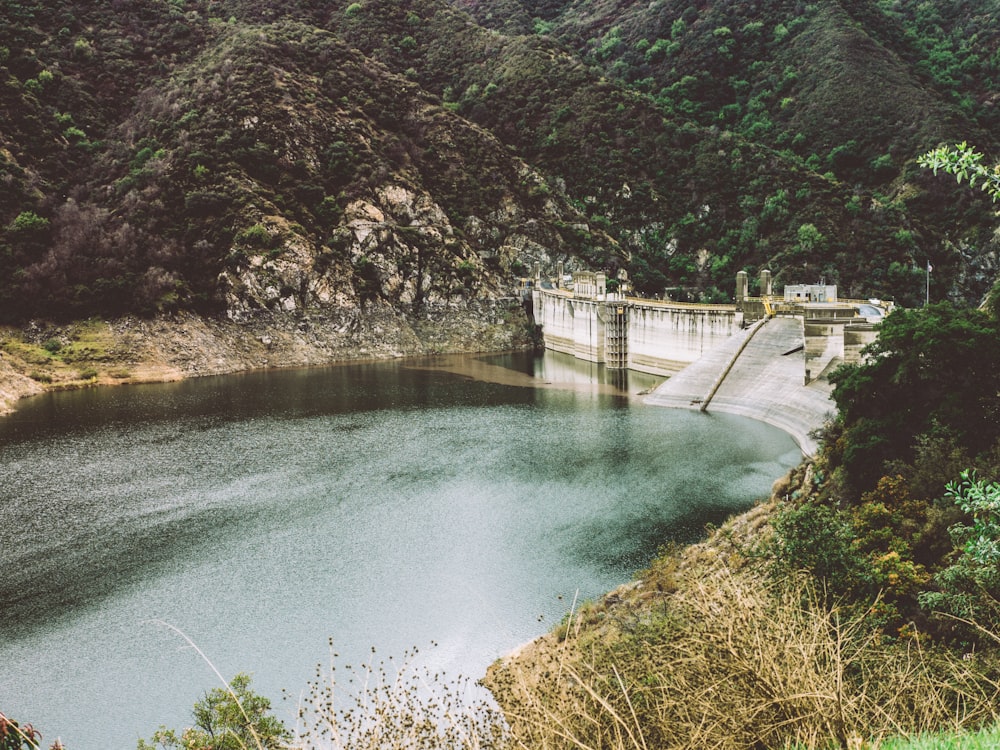 Plan d’eau au milieu des collines et mur de béton