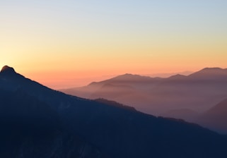 A cinematic shot of a luxury traveler overlooking a serene mountain vista at sunset, bathed in golden light.