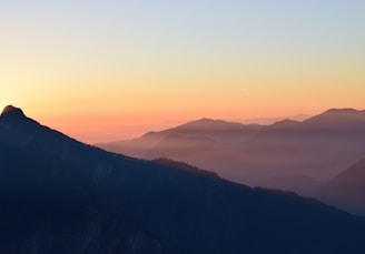 A sweeping aerial view of a serene mountain landscape captured during golden hour.