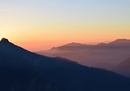 An inviting image of a serene sunset over the Himalayas with hikers enjoying the view.