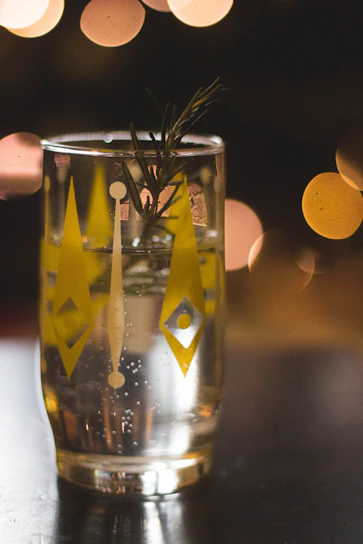 Close-up of a glass filled with golden herbafizz, bubbles rising gently against a soft natural background.