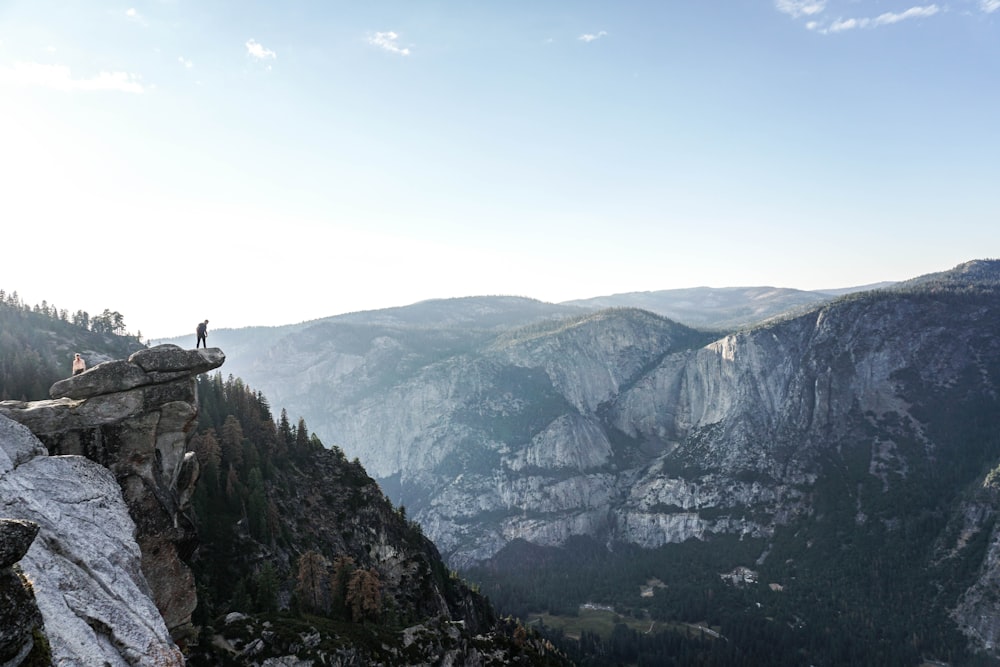 person standing on edge of mountain