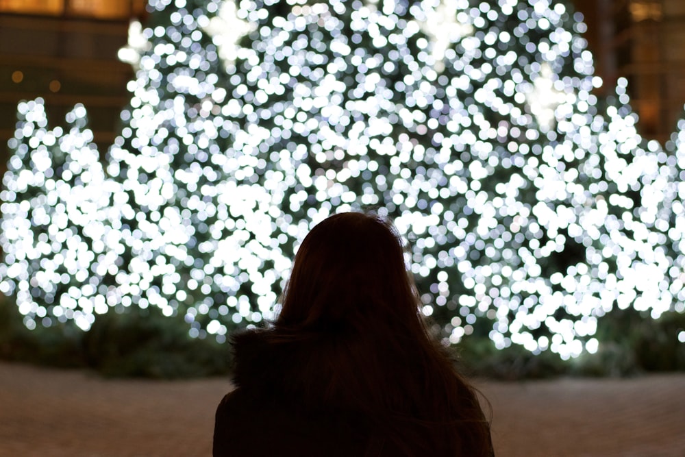 Frau blickt auf Weihnachtsbaum