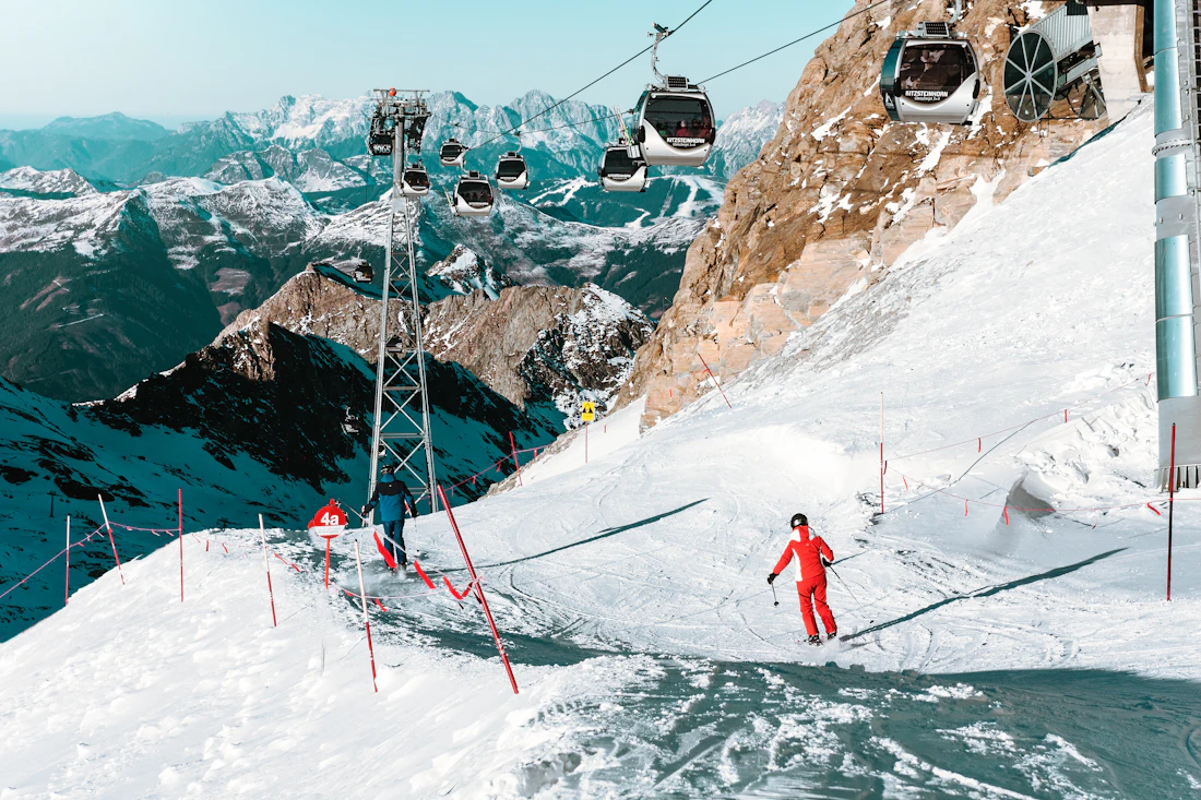 Skiër op een piste onder een kabelbaan op de Kitzsteinhorn