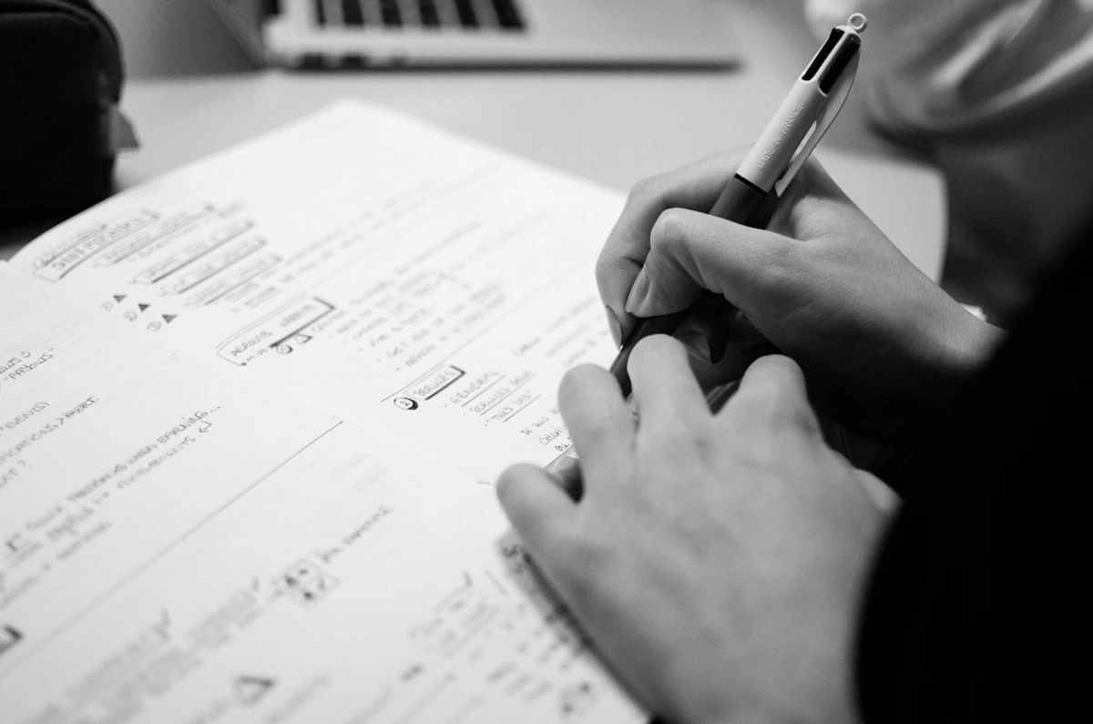 دفتر ملاحظات وقلم يستخدمان للتخطيط لمشروع Portfolio قبل التنفيذ