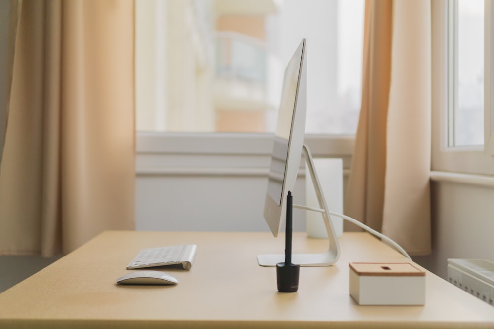 Apple iMac na mesa de madeira perto da janela