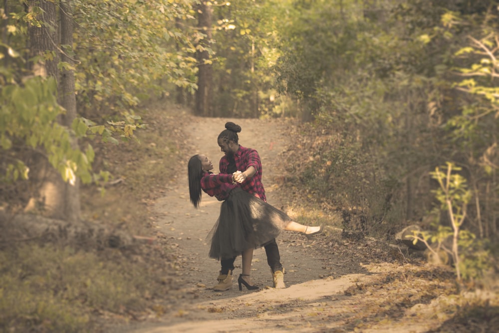 A couple standing in a nature trail embracing each other.