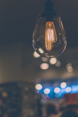 Smart LED bulb with a modern design illuminating a cozy living room setting.