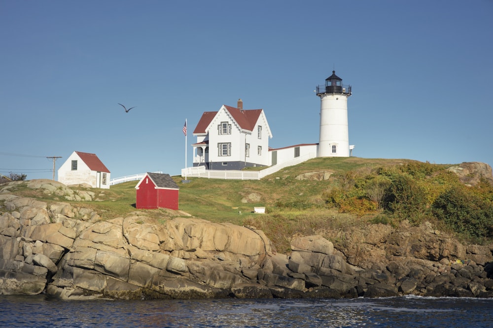 white concrete house near white lighthouse during daytime