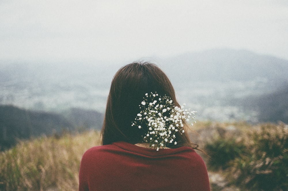 woman wearing red shirt with white flower on back