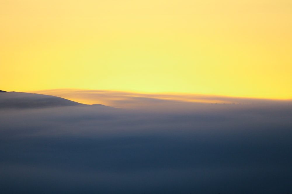 a plane flying in the sky above the clouds