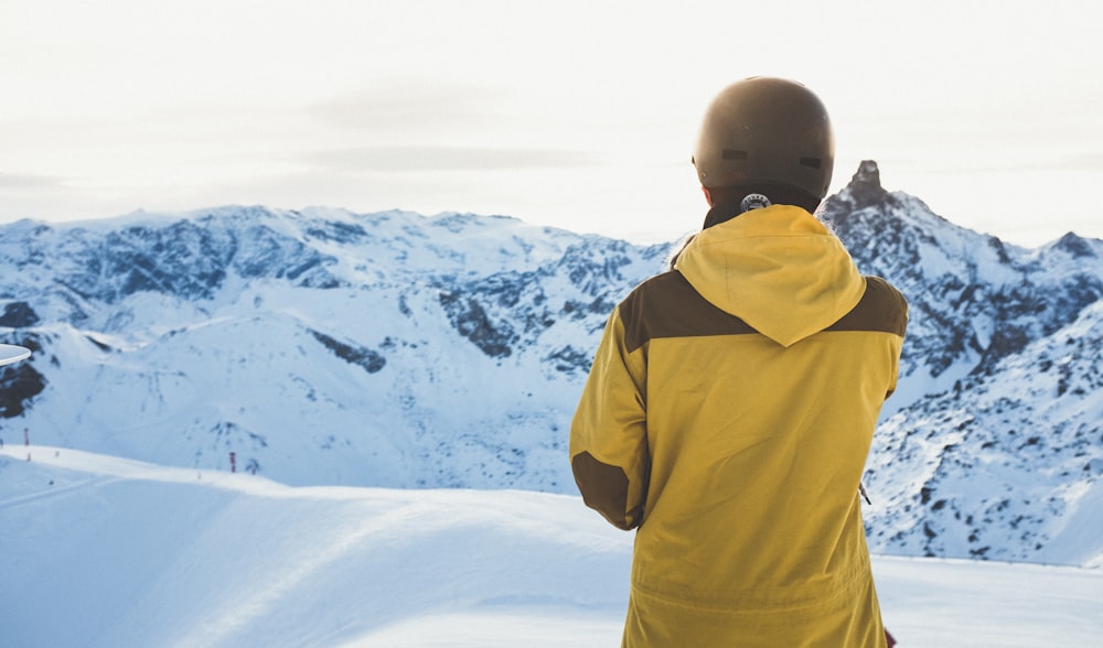 man facing snow covered mountain