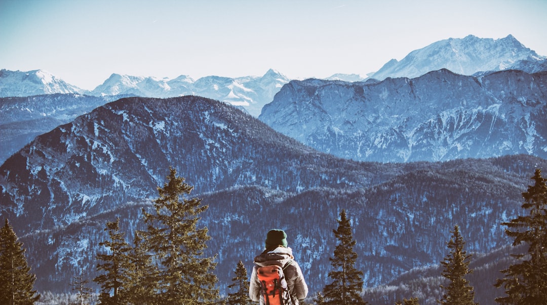 person wearing backpack near mountain during daytim