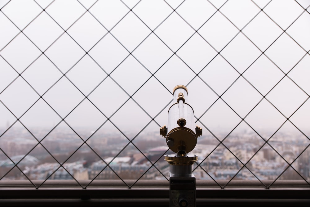 gray and brass-colored telescope facing city buildings