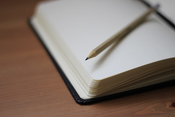 Shallow focus photography of a pencil on a notebook