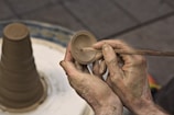 Skilled ceramic specialist applying delicate finishing touches to a dental prosthesis.