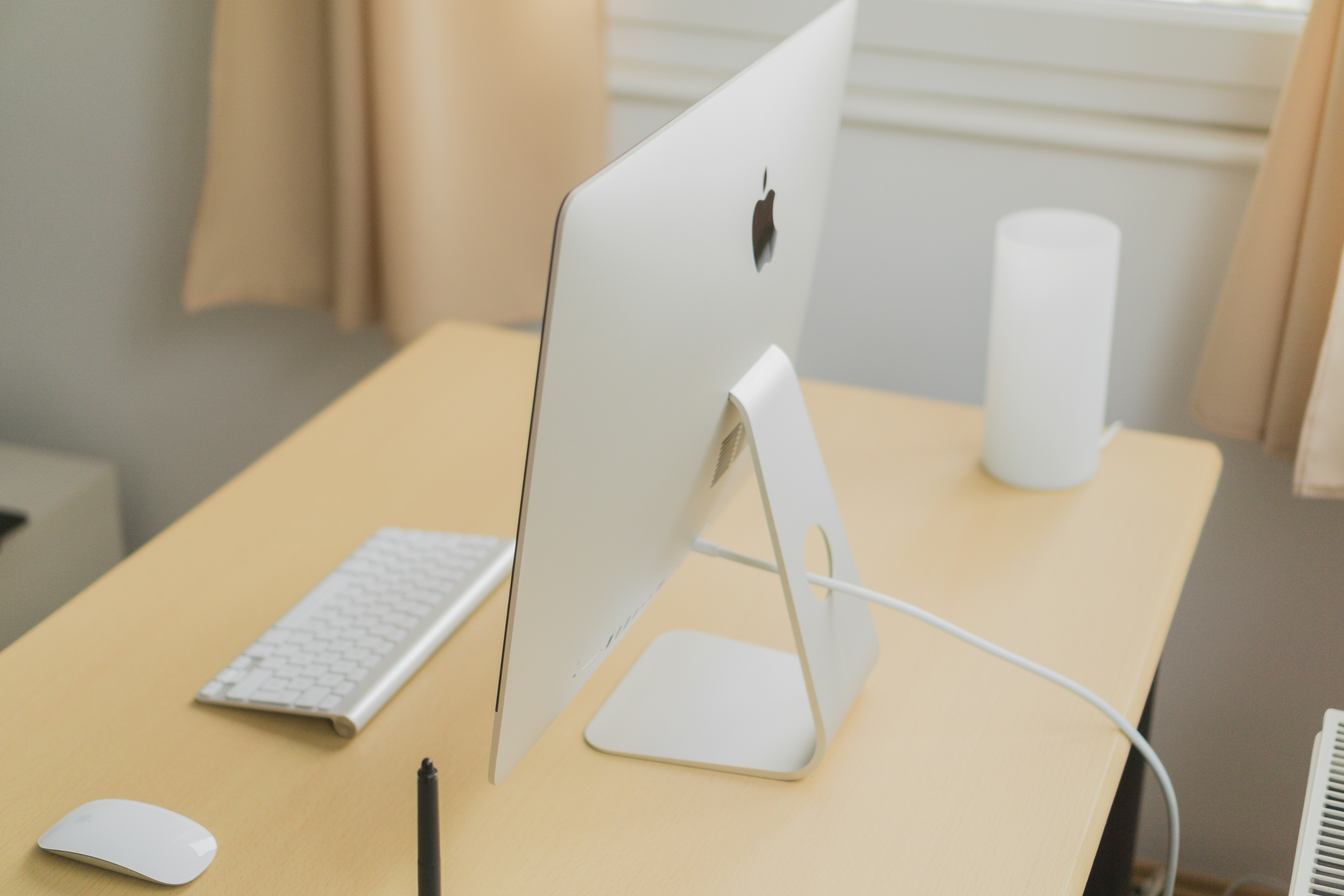 iMac on clean wooden desk, bright warm ambient lighting