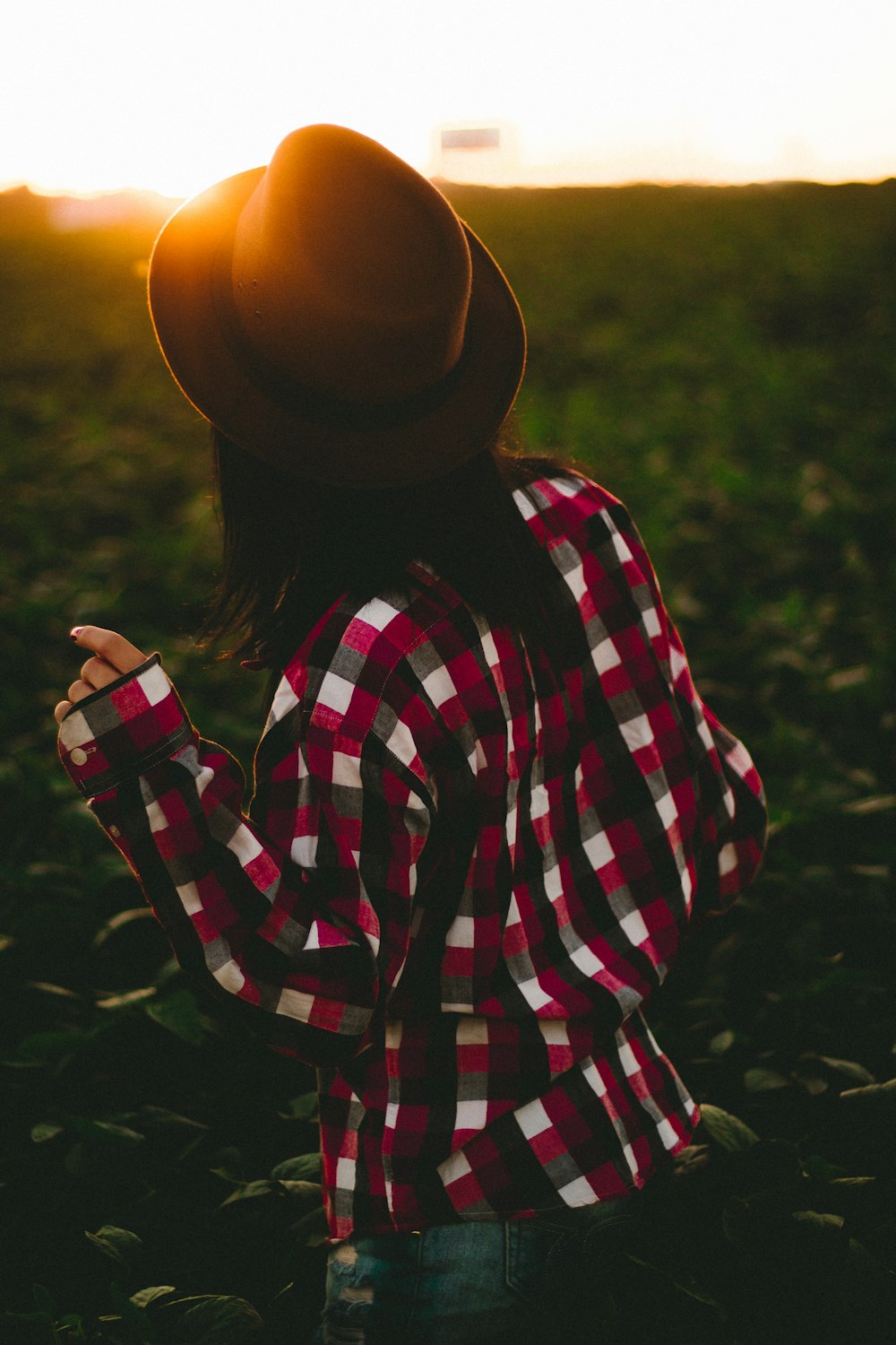 woman wearing hat and checked shirt on green grass