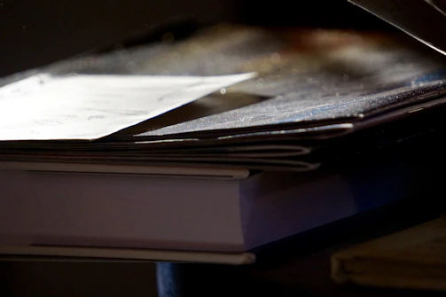 An elegant stack of printed essays with subtle shadows on a white desk.