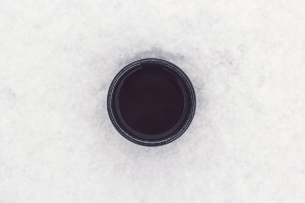 round black container on top of white surface