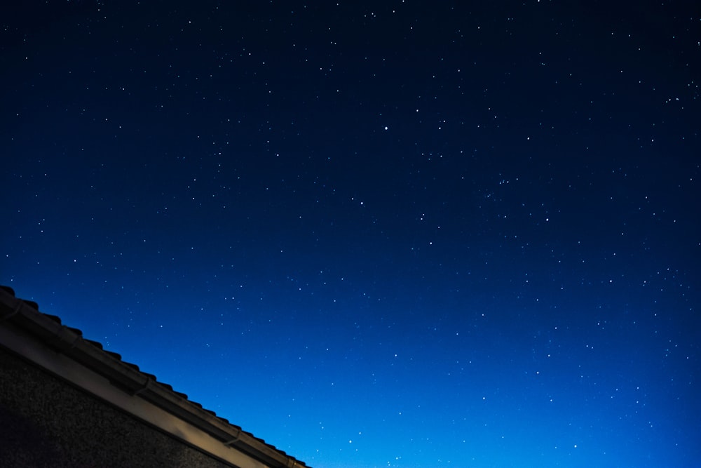 a night sky with stars above a building