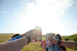 Friends high-fiving after completing a burpout challenge in a sunny park.