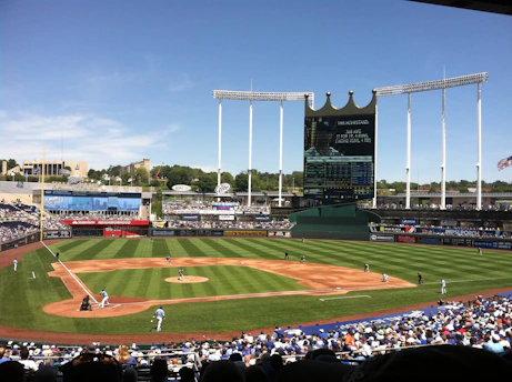 A lively youth baseball game at Estrella Diamante's vibrant field under a clear blue sky.