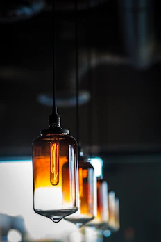 Close-up of a handcrafted pendant light with warm amber tones illuminating a room.