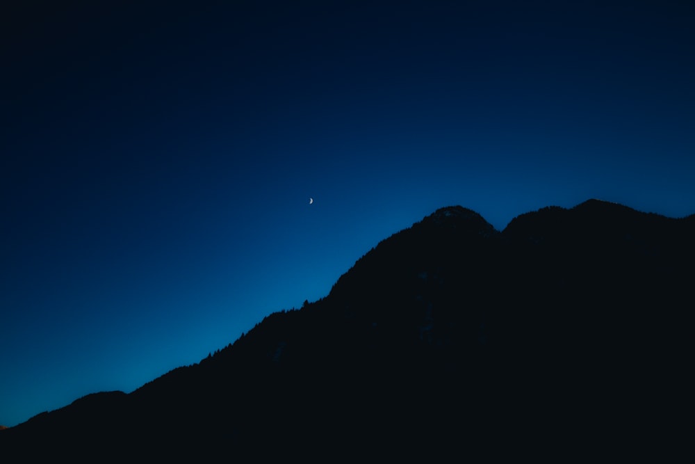 silhouette of mountain under blue sky