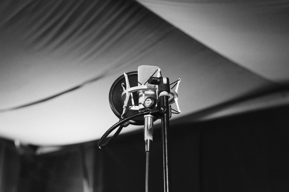 greyscale photo of condenser microphone with stand