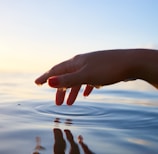 person about to touch the calm water