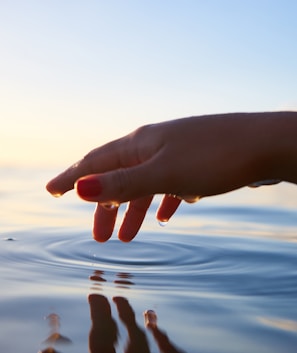 person about to touch the calm water