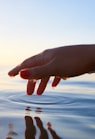 person about to touch the calm water