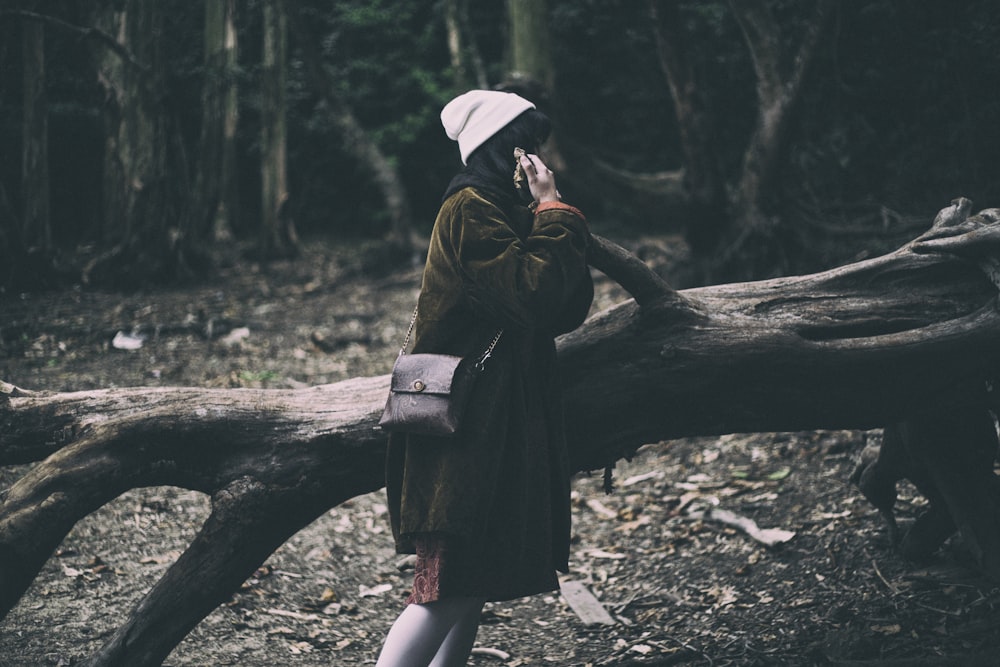 woman standing on tree part during daytime