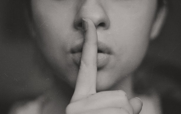 grayscale photo of woman doing silent hand sign