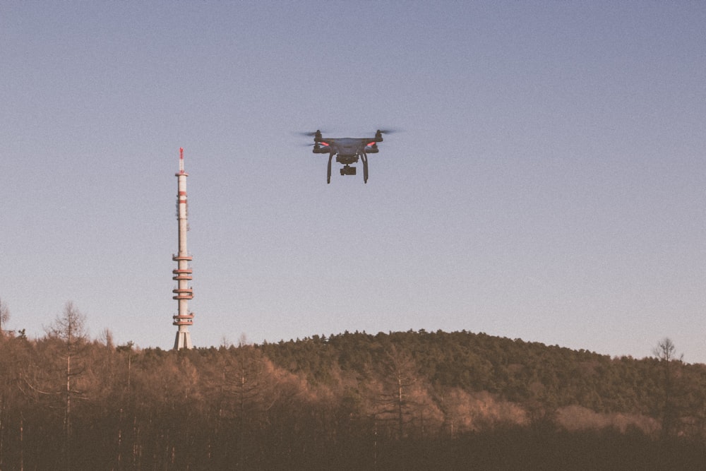 a remote control plane flying over a radio tower